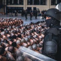 Guardia policial custodia a los detenidos en el Centro de Confinamiento del Terrorismo. Foto: Presidencia de la República de El Salvador.