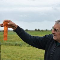 Productor rural enseñando el pluviómetro que marca 25 milímetros llovidos. Foto: Agustín Sartori.